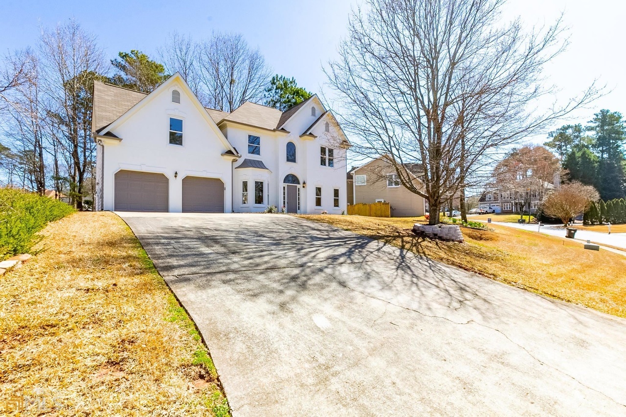 MANAV Capital flagship single-family renovation at Carina Terr, Acworth, GA — two-story home with long driveway.